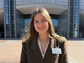 Portrait of a participant standing in front of the European Parliament building in Brussels.