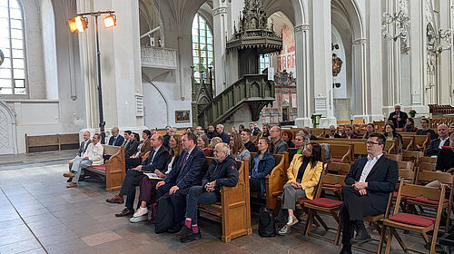 Auftakt der MV-Ostseetage im Dom St. Nikolai Besucherinnen und Besucher sitzen im Dom St. Nikolai in Greifswald während der Eröffnung der MV-Ostseetage 2026.