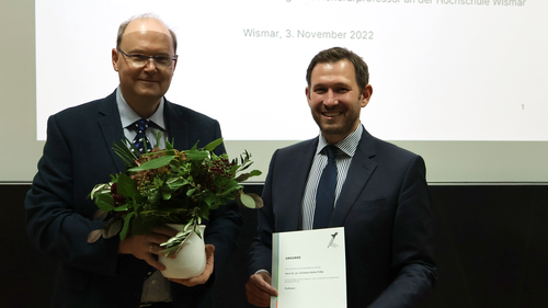 Gruppenbild der Verleihung einer Honorarprofessur. Links mit Blumenstrauß Prof. Dr. Krohn und rechts mit Ernennungsurkunde Prof. Dr. Fröba