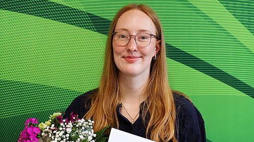 Lara Baumbach für Bachelorarbeit ausgezeichnet Lara Baumbach hält Urkunde und Blumenstrauß nach der Auszeichnung ihrer Bachelorarbeit.