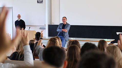 Prof. Dr. Kai Neumann steht vor zahlreichen Studierenden in einem Hörsaal.