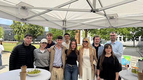 Studierende präsentieren Projektergebnisse Eine Gruppe Studierender steht zusammen mit Prof. Dr. Jantina Nord unter einem Pavillon vor der Hochschulwiese.